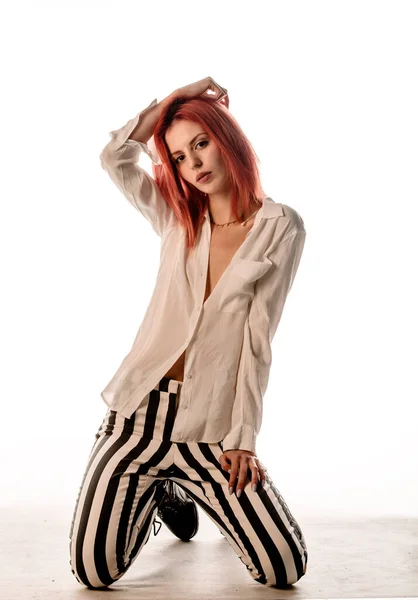 現代的なスタイルのパンツと白のシャツを身に着けている流行の若い赤毛の女性のスタジオボディショット — ストック写真