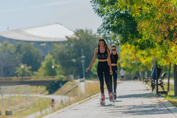 Zwei Schöne Sportlerinnen Beim Rollschuhlaufen Park Einem Sonnigen Tag — Stockfoto