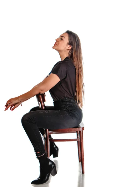 スタイリッシュな若いです女性身に着けています黒服ながら座っています上の椅子で現代的なスタジオ — ストック写真