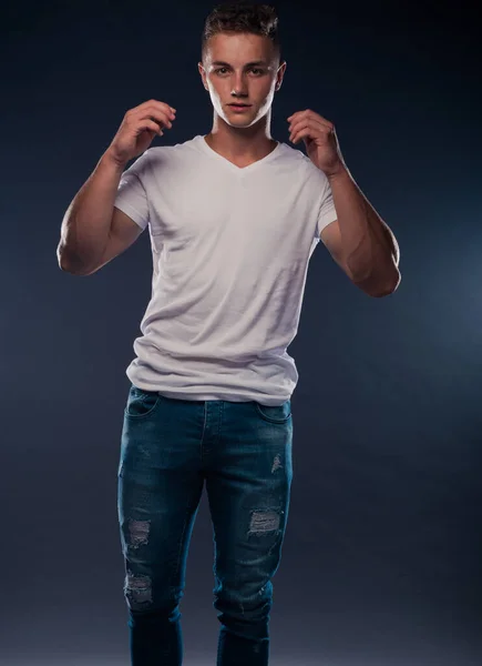 Модний Красивий Чоловік Позує Синіх Джинсових Штанях Білому Верхньому Спортивному — стокове фото