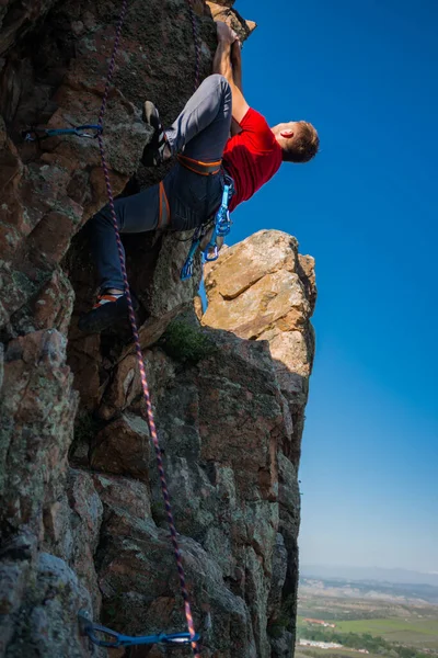 頂上に着く前に岩に登る男 — ストック写真