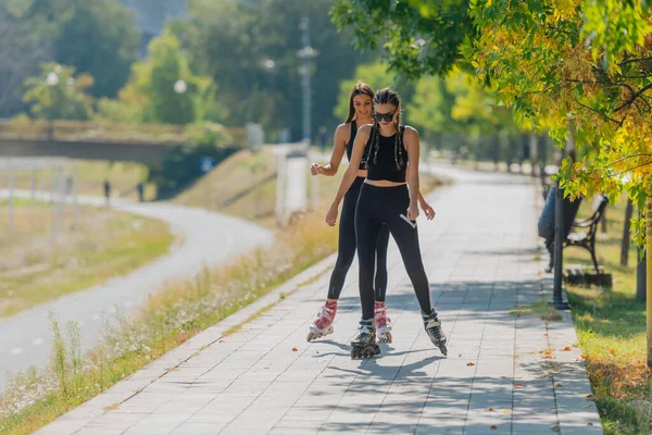 Duas Belas Esportistas Patinando Parque Dia Ensolarado — Fotografia de Stock