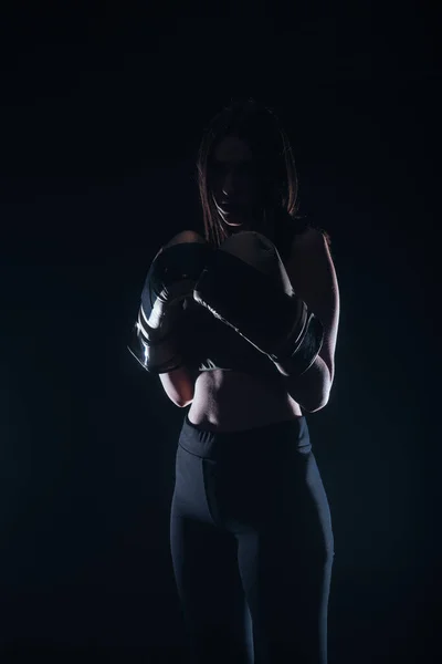 一个性感身材的女人穿着深色的拳击手套摆出一副人物形象 — 图库照片