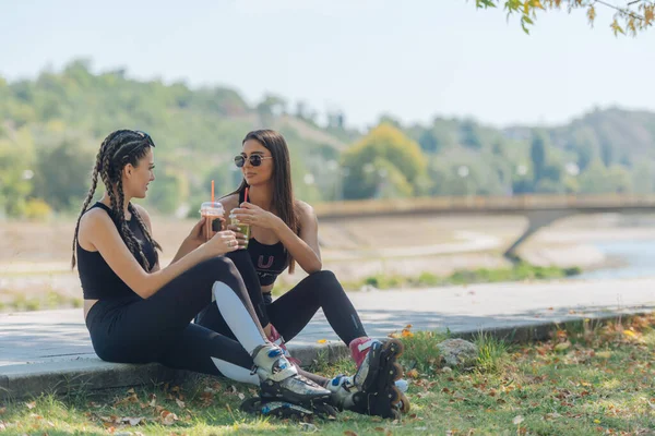 Due Ragazze Siedono Parco Mentre Prendono Una Pausa Dal Pattinaggio — Foto Stock