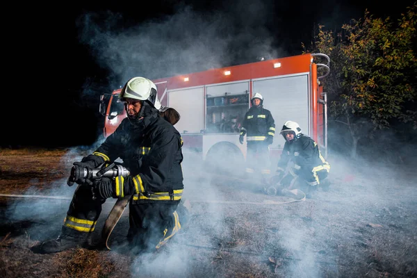 Firemen outfitted with gear during a firefighting operation