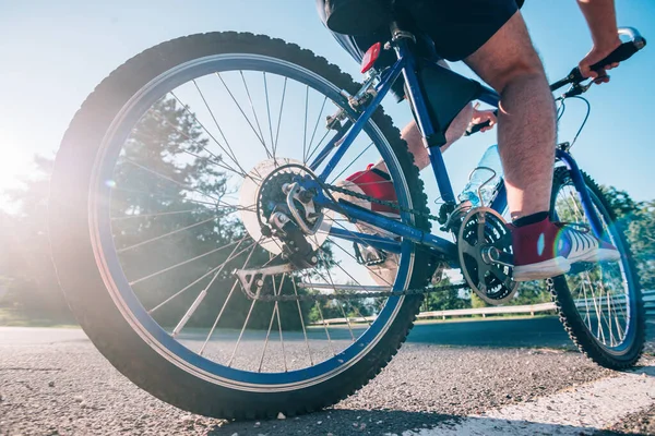 日落时分 当太阳通过他的车轮时 骑自行车骑自行车骑自行车骑在柏油路上的男性骑手很健康 — 图库照片