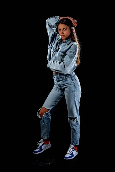 一个穿着时髦斜纹棉裤和夹克的现代女孩的工作室时尚肖像 — 图库照片