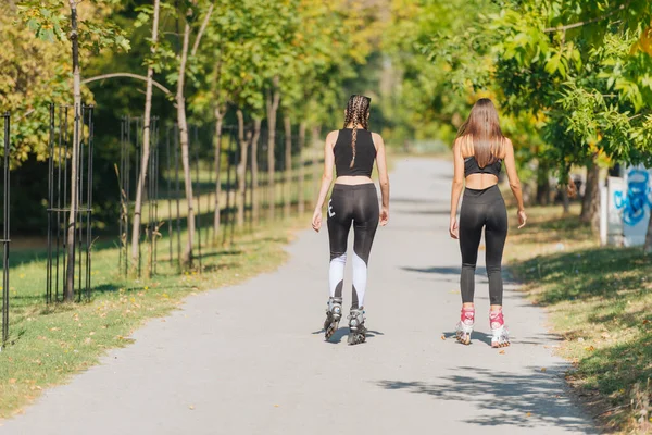 Achteraanzicht Van Twee Jonge Fitte Vrouwen Rolschaatsen Buitenlucht Straat Het — Stockfoto