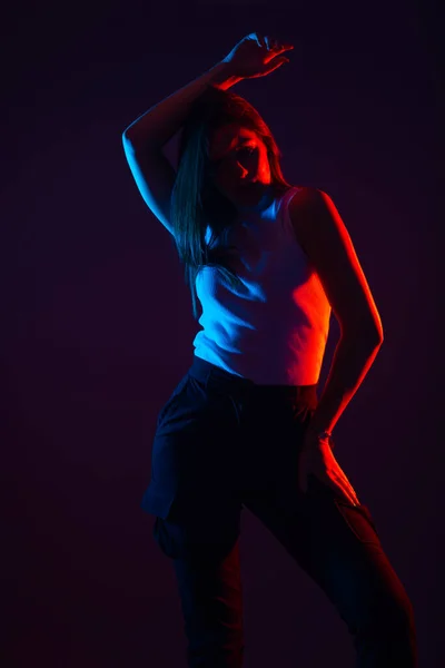 コントラストの高い黒の背景に女性モデルの青と赤の光の肖像画 — ストック写真