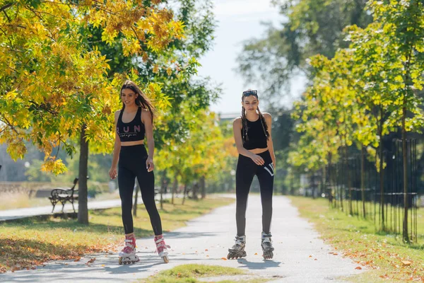 Pełna Długość Zdjęcie Seksownych Kobiet Uprawiających Sporty Rolki Parku — Zdjęcie stockowe