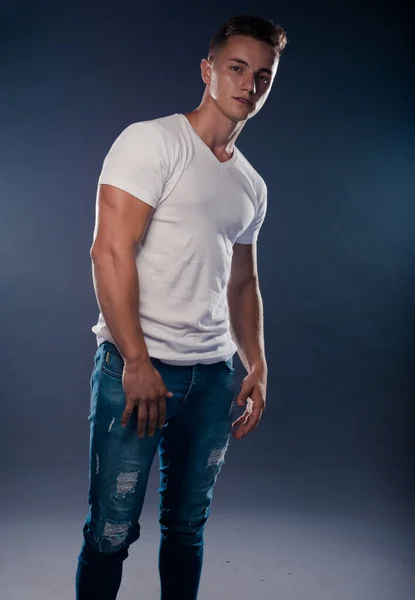Cool Ung Man Klädd Vit Shirt Och Blå Jeans Poserar — Stockfoto