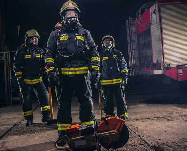 Група Трьох Молодих Пожежників Позують Всередині Пожежного Відділу Уніформою Інструментами — стокове фото