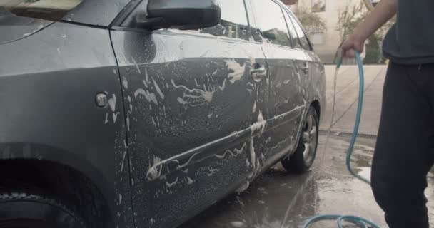 晴れた日にガレージの前で父親の車を洗っている男の子 — ストック動画