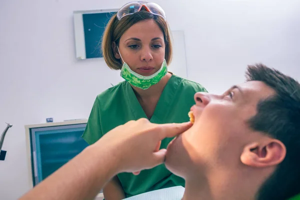 Zbliżenie Nastoletniego Pacjenta Pokazującego Ból Zęba Swojej Dentystce Gabinecie Dentystycznym — Zdjęcie stockowe