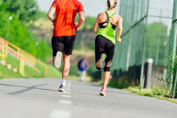 公園を走る若いスポーツカップルの後ろからの眺め — ストック写真