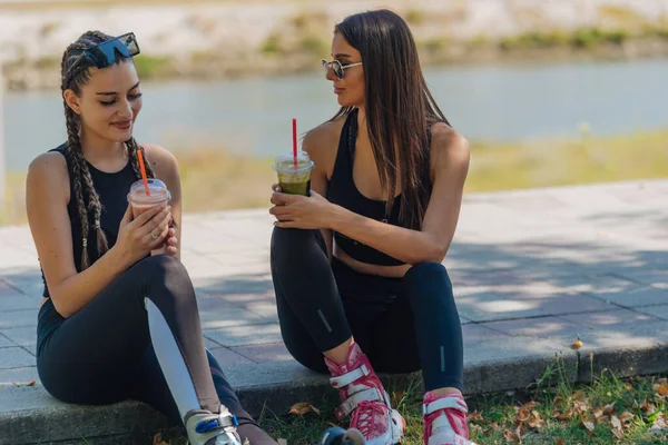 Due Ragazze Siedono Parco Mentre Prendono Una Pausa Dal Pattinaggio — Foto Stock