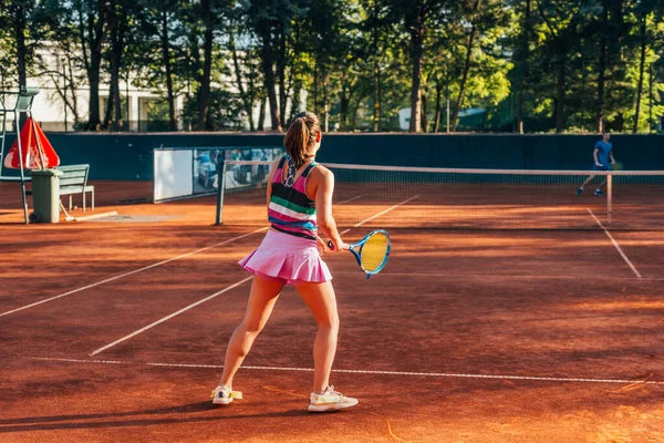 コートの外でテニスをしている若い女性の背中からの眺め — ストック写真