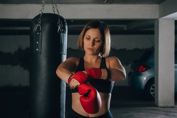 Selbstbewusste Junge Frau Zieht Ihre Roten Boxhandschuhe — Stockfoto