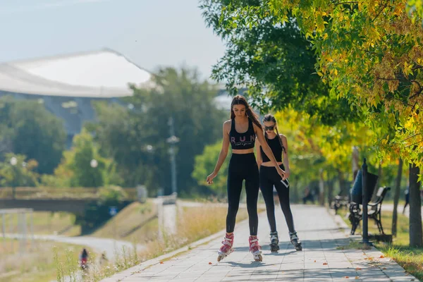 Zwei Schöne Sportlerinnen Beim Rollschuhlaufen Park Einem Sonnigen Tag — Stockfoto