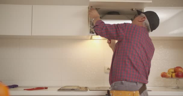 Tukang Dengan Alat Sabuk Memperbaiki Ventilasi Udara Dapur — Stok Video