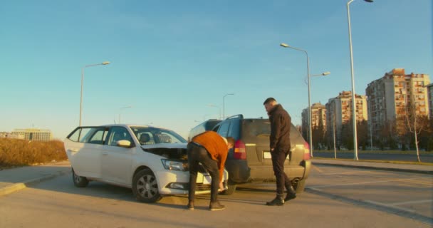 Незнакомцы Осматривающие Автомобильную Аварию Посреди Дороги — стоковое видео