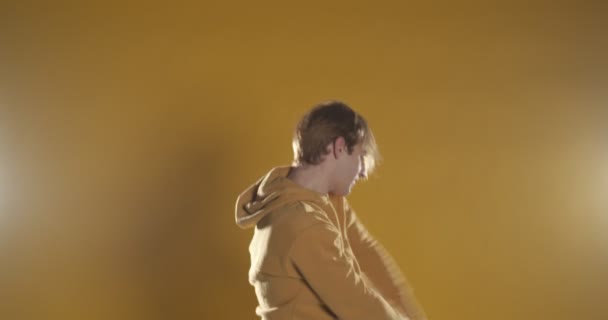 男性ダンサー 遅い動きでスタジオで黄色に隔離されたパフォーマンス — ストック動画