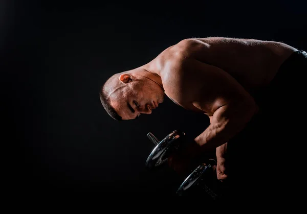 집중력 근육질의 남자가 덤벨을 가지고 운동을 — 스톡 사진