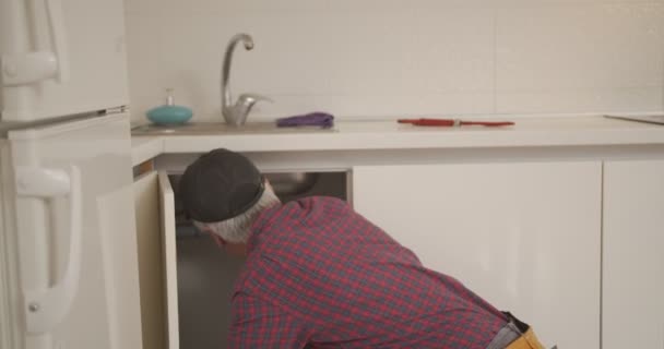 Senior Plumber Fixing Kitchen Sink — Stock Video