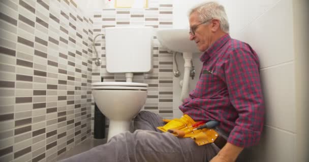Starszy Pracownik Naprawia Toaletę Łazience — Wideo stockowe