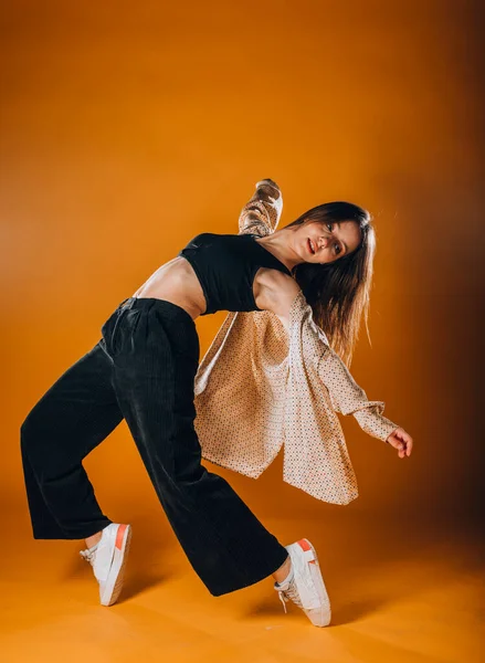Подтянутая Молодая Танцовщица Выполняет Танцевальную Программу Оранжевой Студии — стоковое фото