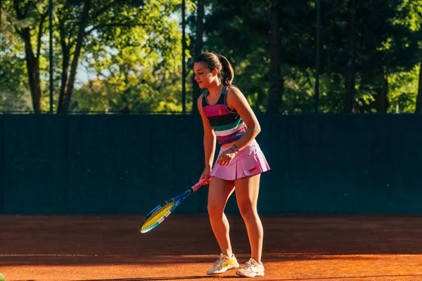 若い女性のテニス選手は テニスの試合が始まるのを待っている間にラケットで地面にボールを打つ — ストック写真