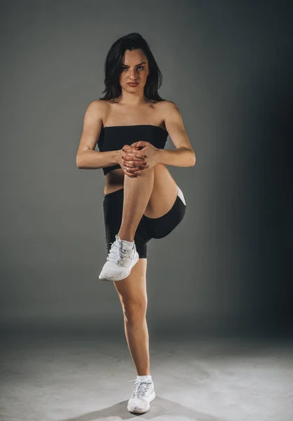 Muscular Atractiva Mujer Fitness Calentamiento Estudio Sobre Fondo Gris —  Fotos de Stock