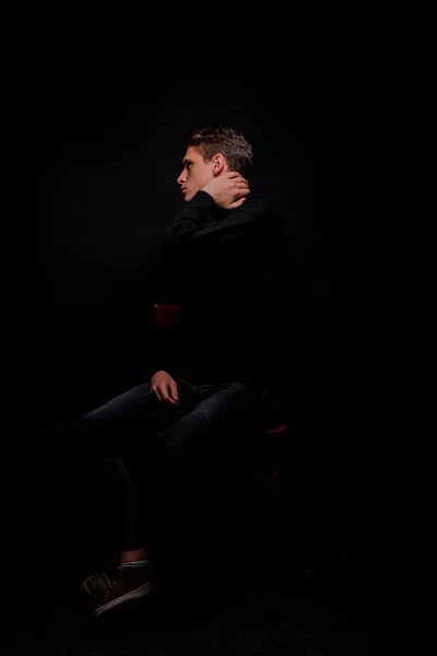 トレンディなハンサムな男ポーズでトレンディーな長袖シャツ座っている椅子 — ストック写真