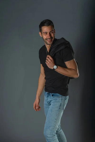 Modelo Masculino Musculoso Fuerte Jeans Con Camiseta Negra Sosteniendo Chaqueta — Foto de Stock