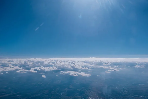 从飞机的窗户看到的白云和晴朗的天空 — 图库照片