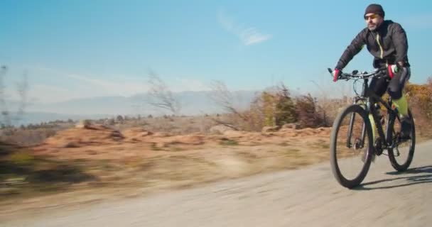 山の丘の上の道路で自転車に乗るフルタイムの自転車乗り — ストック動画