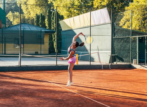 粘土のコートで奉仕する若い女性テニス選手 — ストック写真