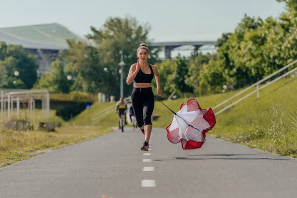 Sportvrouw Training Het Park Hardlopen Met Een Weerstand Parachute Vastgebonden — Stockfoto