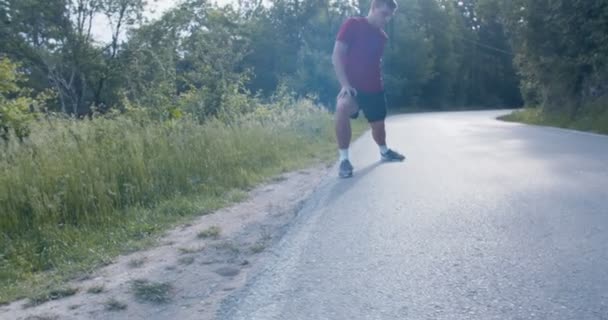 Jongeman Strekte Zijn Benen Voordat Hij Bergweg Rende — Stockvideo