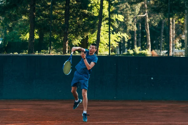 プロのテニス選手が粘土のテニスコートでボールを提供しています — ストック写真