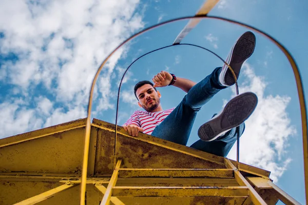 Jovem Está Sentado Alta Construção Ferro Olhando Frente Céu — Fotografia de Stock