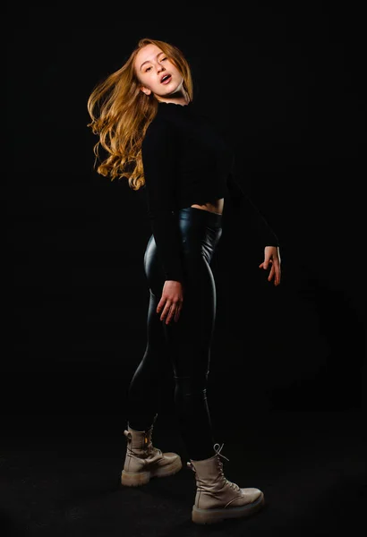 Mladá Žena Sobě Kožené Černé Kalhoty Izolované Tmavém Pozadí — Stock fotografie