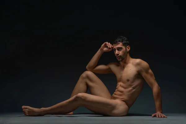 男模的时尚裸照 形象迷人的男模孤零零地坐在工作室的地板上 — 图库照片