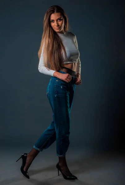 スタイリッシュなブルーデニムパンツと長いブラウスに身を包んだ魅力的な若い女性モデル — ストック写真