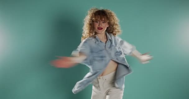 穿牛仔裤的女孩穿着蓝色的拖鞋跳舞 — 图库视频影像