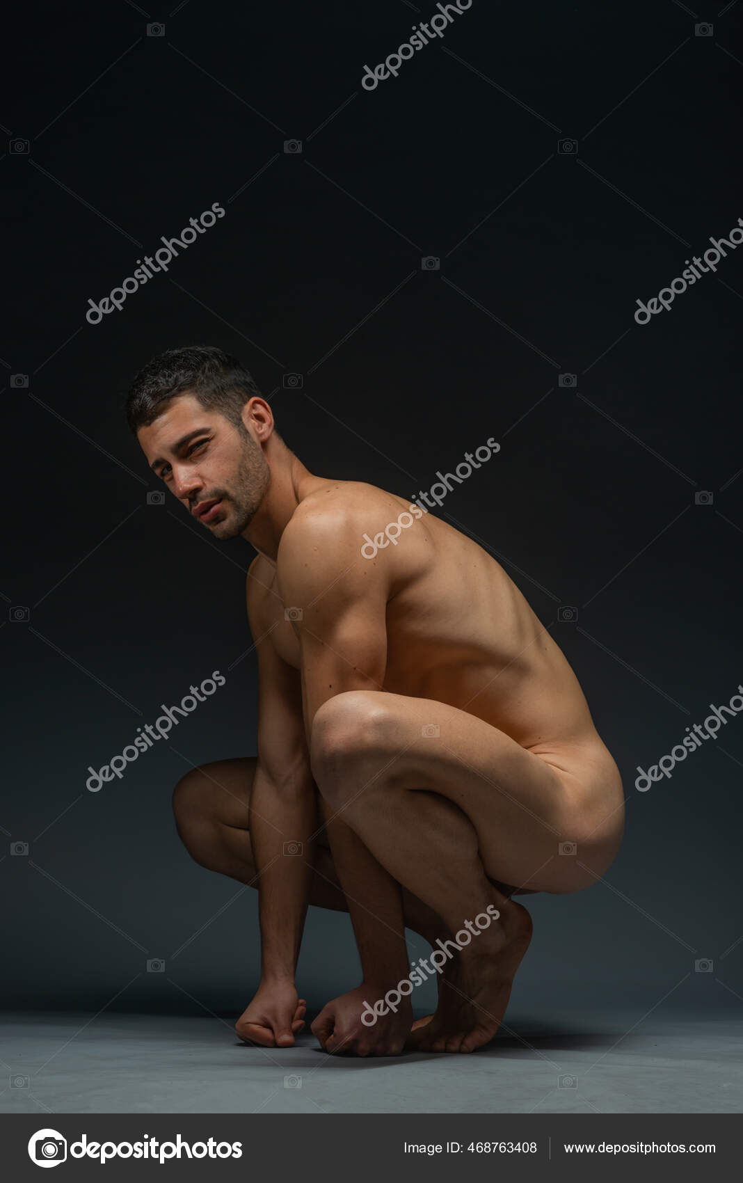 一个裸体男模蹲在黑人摄影棚背景的画像— 图库照片©gorgev＃468763408