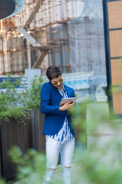 Städtischer Geschäftsmann Arbeitet Seinem Tablet Während Mit Seinen Partnern Telefoniert — Stockfoto