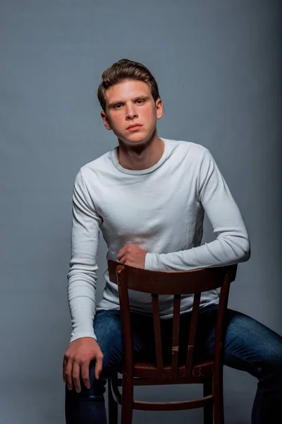 Retrato Homem Elegante Atraente Sentado Uma Cadeira Posando Contra Fundo — Fotografia de Stock