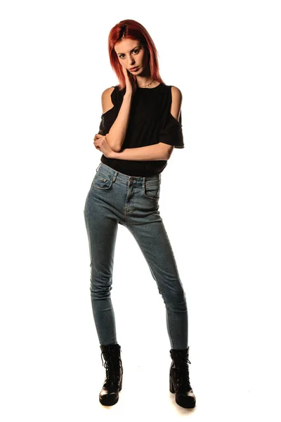 スタイリッシュなデニムパンツとブラックトップを身に着けている現代の女の子のスタジオファッションの肖像画 — ストック写真