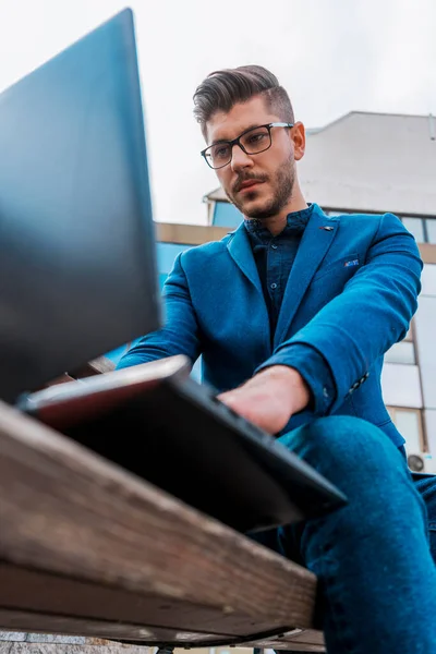 Bonito Jovem Empresário Usando Seu Laptop Para Trabalhar Perto Cidade — Fotografia de Stock